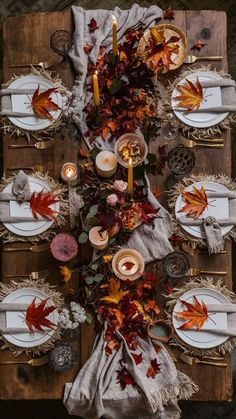 an overhead view of a table set with fall leaves and candles