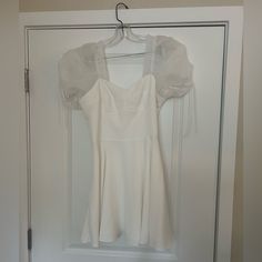 a white dress hanging on a hanger