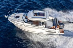 a man driving a white boat in the ocean