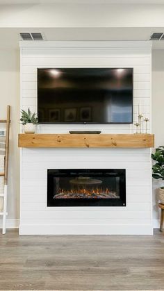 a white fireplace with a flat screen tv above it