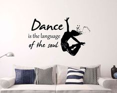 a living room with a couch and wall decal that says dance is the language of the soul