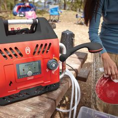 a woman is using an electric generator on a picnic table