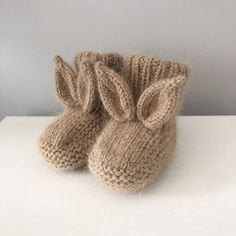 a pair of knitted baby booties sitting on top of a white countertop