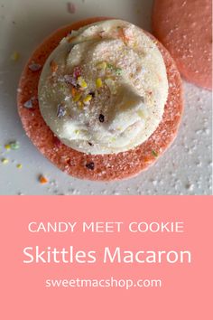 two cookies with white frosting and sprinkles are on a pink plate