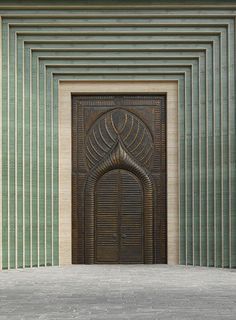 two people are running in front of a building with an intricate door and green striped walls