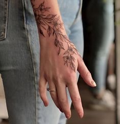 a woman's hand with a flower tattoo on it