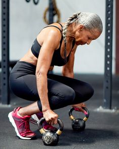 a woman squatting down with two kettles in front of her and looking at the ground