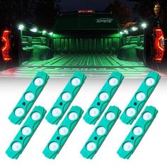 four green led lights on the back of a truck at night with trees in the background