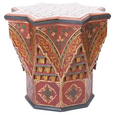 an elaborately painted table with intricate designs on the top and sides, in red