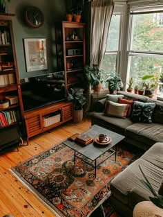 a living room filled with furniture and a flat screen tv sitting on top of a wooden floor