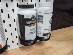 two bottles of multi - surface paint sitting on a shelf next to each other in a store