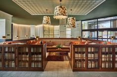 the library has many bookshelves and tables in it, along with two chandeliers hanging from the ceiling