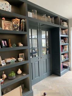 a room that has some bookshelves on the wall and shelves in front of it