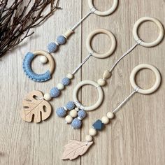 the wooden beads are hanging from the string on the table next to some leaves and branches