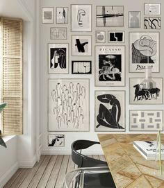 a room with many pictures on the wall and a table in front of it,