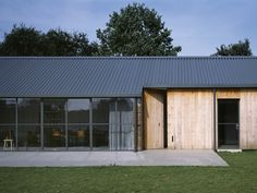 a house that is made out of wood and metal with glass doors on the outside