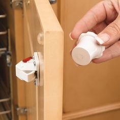 a person is opening a cabinet door with an object in their hand and the light on