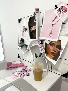 a cup of coffee sitting on top of a white desk next to a computer monitor