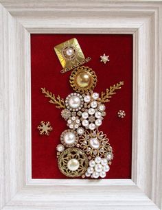 a red and white frame with a snowman made out of pearls, brooches and other items