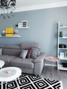 a living room filled with furniture and a chandelier hanging from the ceiling above