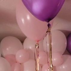 purple and white balloons are floating in the air with gold chains attached to each balloon