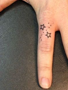 a person's hand with a small star tattoo on it