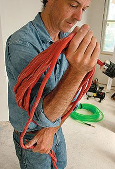 a man in blue shirt holding red cords