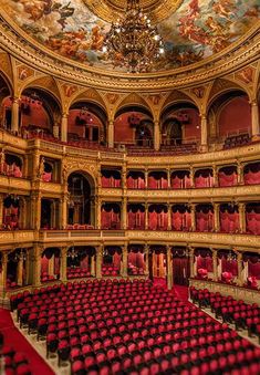 an ornate auditorium with red seats and chandelier