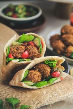 two wraps filled with meatballs and veggies on top of burloom