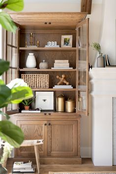 a living room with a fireplace and wooden shelves filled with books, vases and other items