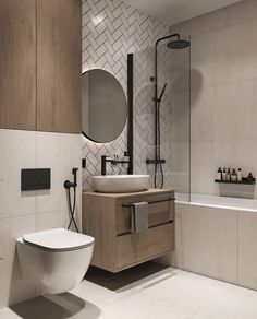 a white toilet sitting next to a bath tub in a bathroom under a round mirror