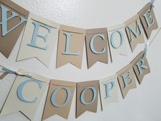 a welcome sign hanging from the side of a wall next to a blue and white banner