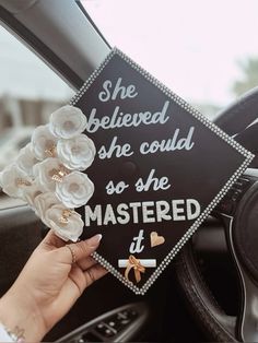 a graduation cap that says she believed she could so she mastered it with flowers