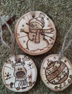 three wooden ornaments with designs on them sitting on the floor next to some string and twine