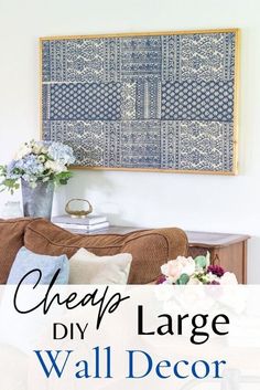 a blue and white wall hanging over a couch in a living room with the words cheap diy large wall decor