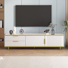 a living room with a large television on top of a white entertainment center next to a book shelf