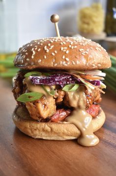 a chicken sandwich with lettuce, tomato and onion on a sesame seed bun