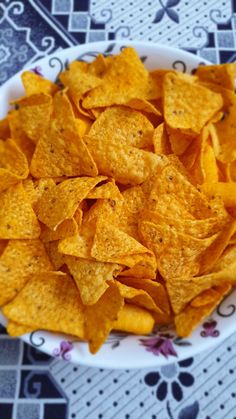 a white bowl filled with tortilla chips on top of a table