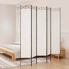 a room divider in the middle of a bedroom with a white bed and wooden floor