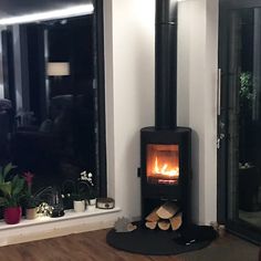 a wood burning stove in a living room next to a window with open glass doors