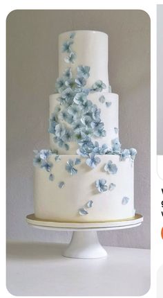 a white wedding cake with blue flowers on it