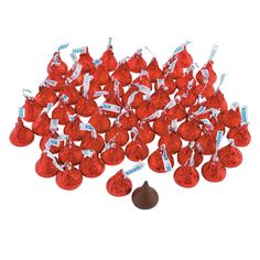 a bunch of red and white candies on top of each other with one chocolate candy in the middle