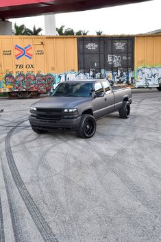 a gray truck parked in front of a train track