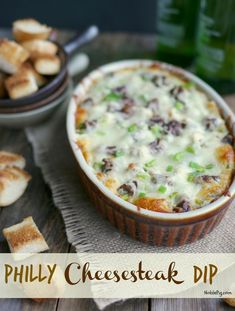 a casserole dish with cheese and green onions in it on a wooden table