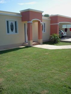 a pink house with white shutters in the front yard