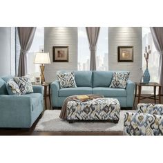 a living room filled with blue couches and pillows on top of a wooden floor