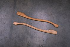 two wooden spoons sitting on top of a cement floor