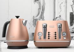 two toasters sitting next to each other on top of a white counter with silver trim