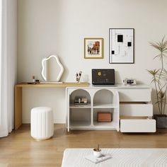 a living room with white furniture and wood flooring, including a desk that has a laptop on it