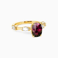 a yellow gold ring with a large pink tourmaline and white diamonds on the side